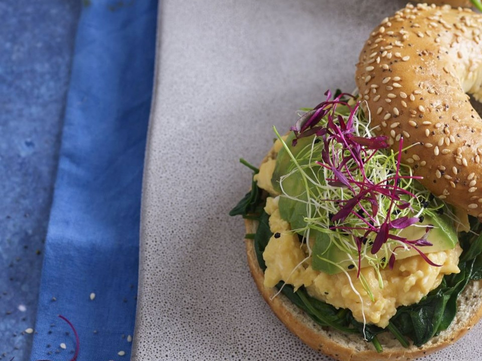 Bagels com ovos mexidos, abacate e espinafres