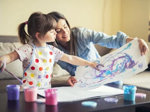 imagem de mãe e filha a pintar com tinta numa folha de papel